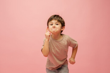 Gremaces. Happy, smiley little caucasian boy isolated on pink studio background with copyspace for ad. Looks happy, cheerful. Childhood, education, human emotions, facial expression concept.