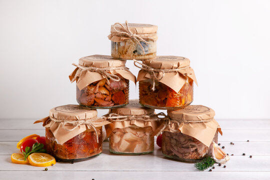 Homemade Canned Meat From Farm Poultry-goose, Duck, Chicken, Pork And Beef, Canned Fish From Mackerel. A Pyramid Of Glass Cans With Canned Food