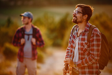 two men hikers enjoy a walk in nature, sunset time in summer