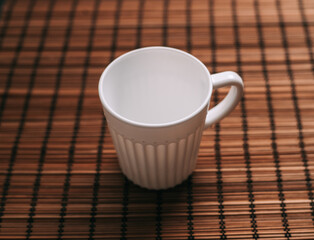 white mug on a wooden stand stands on the table top view