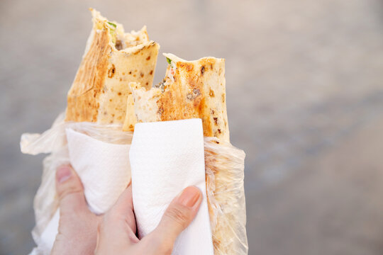 Closeup male and female hand holding doner kebab or shawarma, lifestyle outdoors