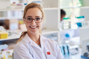Smiling young female technician working in a lab