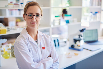 Confident young female technician standing in a lab