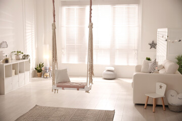 Beautiful swing with pillow in living room. Stylish interior design