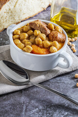 Chickpea stew dish (Madrid stew). With beef, chorizo, bacon, carrots and olive oil. Mediterranean diet. Homemade look. With copy space.