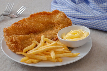 Crispy fish and chips on white plate