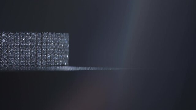 Brilliant diamond bracelet rotating in black background.