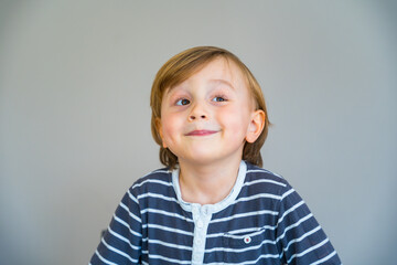 Close up portrait of a toddler boy of two years old indoor. Happy child wearing striped t shirt...