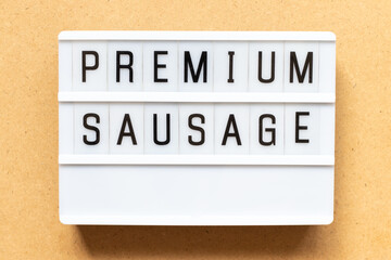 Lightbox with word premium sausage on wood background