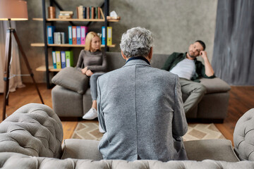 Obraz premium Rear view of psychotherapist listening to depressed spouses