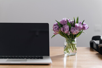 Workplace at home office with laptop and tulips flowers. 8 march. springtime. slow living. mindful work life balance. woman at work