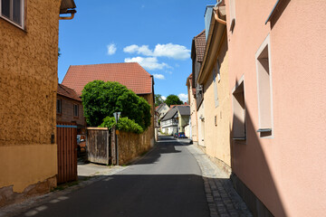 Fototapeta na wymiar A street with houses in Ostheim vor der Rhön, Germany
