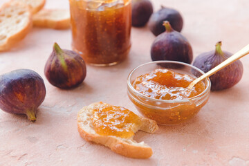 Bowl with sweet fig jam on color background