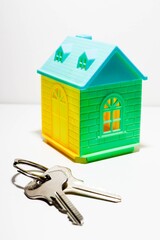 A closeup shot of a green and yellow house and keys. A new home concept