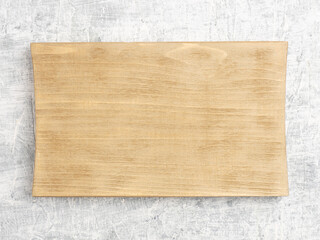 Brown wooden cutting board on white concrete background