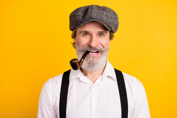 Photo portrait of man in retro outfit smoking wooden pipe smiling isolated bright yellow color background