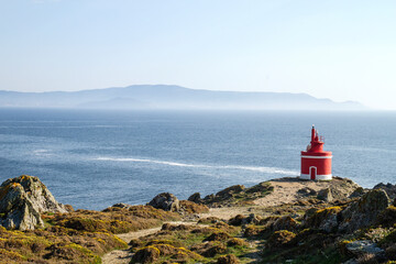 Fototapeta na wymiar Old red lighthouse in Punta Robaleira and Islas Cies from Cabo Home, Pontevedra, Spain