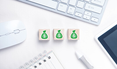 Money bag on wooden cubes and business objects.