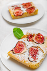 Plate with slice of delicious fig pie on light background