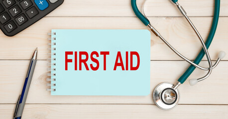 Notepad with the inscription FIRST AID and stethoscope