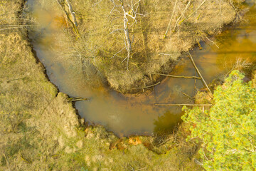 Mała, nieuregulowana rzeka płynąca przez las. Zdjęcie z drona.