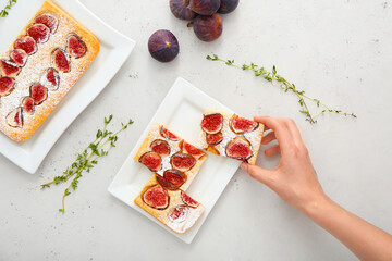 Woman with slice of delicious fig pie on light background