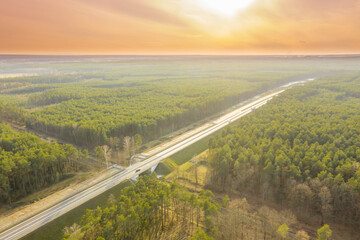 Betonowa, dwupasmowa droga w świetle zachodzącego słońca. Zdjęcie z drona.