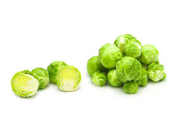 Fresh organic brussels sprouts in heap, whole and halves, isolated on white background.	