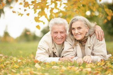 portrait of beautiful senior couple lying in park