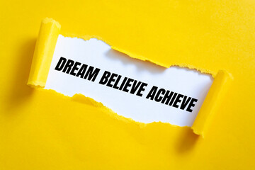 Dream Believe Achieve. Words written under torn paper. Motivation concept text.