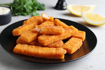 Fresh breaded fish fingers served on white table