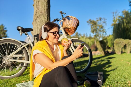 Happy Relaxing Mature Woman In Headphones With A Smartphone