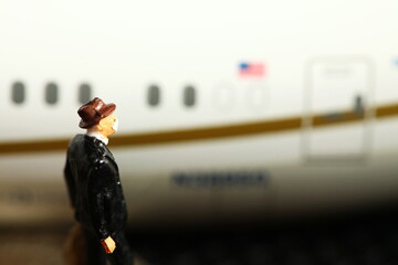 Miniature model plane and businessman wearing mask figure model scene.
