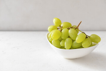 Plate with ripe green grapes on white background