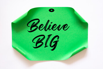 The words Believe BIG written on a white notebook to remind you an important appointment.