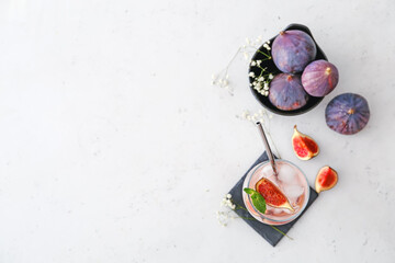 Composition with tasty fig lemonade on light background