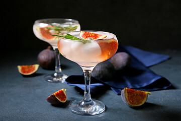 Glasses of tasty fig lemonade on dark background