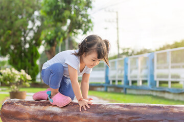 Happy Asian baby child girl aged of 2-3 years old playing with a toy. She practice to crawling and walking at the playground. Development of baby concept.