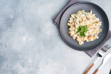 Olivier salad with mayonnaise on a plate. Russian is a traditional festive dish.