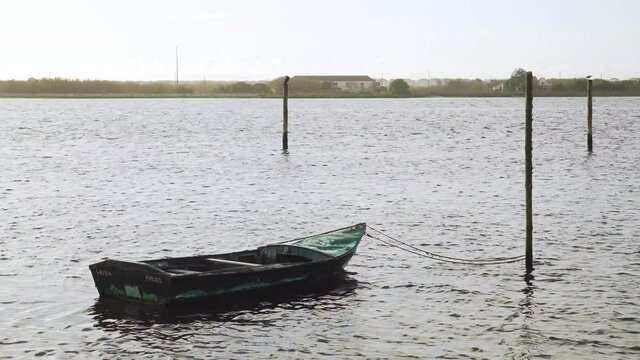 4K wooden boat moored in Ria de Aveiro, old boat moving on the river current. 60fps