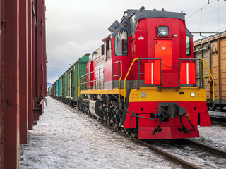 Switcher with train of freight cars in line at a rail yard. Small desel manoeuvring locomotive