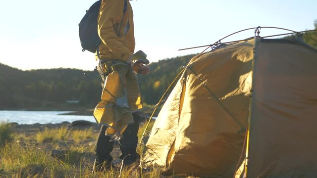 Assembling rain-fly and final pieces in camping tent in Swedish Wild - Ground-level Orbit tracking slow-motion shot