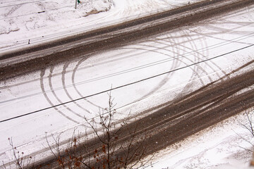 tram lines and tyre tracks surrounded by trees and snow