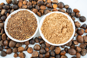 Tea bran powder and camellia seeds on white background