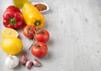 Tomatoes, bell peppers, olive oil, silician lemon and garlic over wooden table with copy space. Mediterranean food