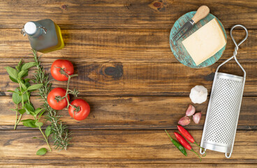 Tomatoes, olive oil, parmesan cheese, herbs and garlic over wooden table with copy space. Mediterranean food