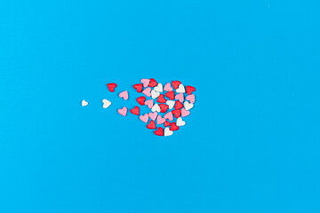 small white, pink and red hearts forming a bigger heart on blue background