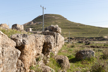 Fototapeta na wymiar The ruins of outer part of the palace of King Herod, against the background of the filled artificial hill in which they are located the palace of King Herod - Herodion,in the Judean Desert, in Israel