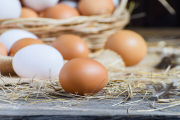 Fresh eggs are placed on a wooden table and fresh eggs are placed in a basket in an organic farm.