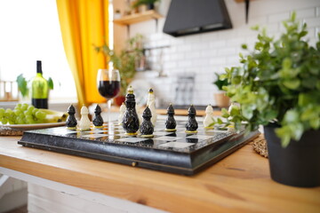 Close up of beautiful chess on table in kitchen. Selective focus of porcelain chess pieces on chessboard.